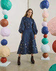 Hunter Bell NYC Ida Skirt in a vibrant art studio setting with colorful paper sphere sculptures.