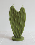 The Faire Nopal Cactus Beeswax Candle features two wicks and stands upright on a circular base, beautifully shaped like a cactus paddle—an eye-catching piece of home décor shown against a plain white background.