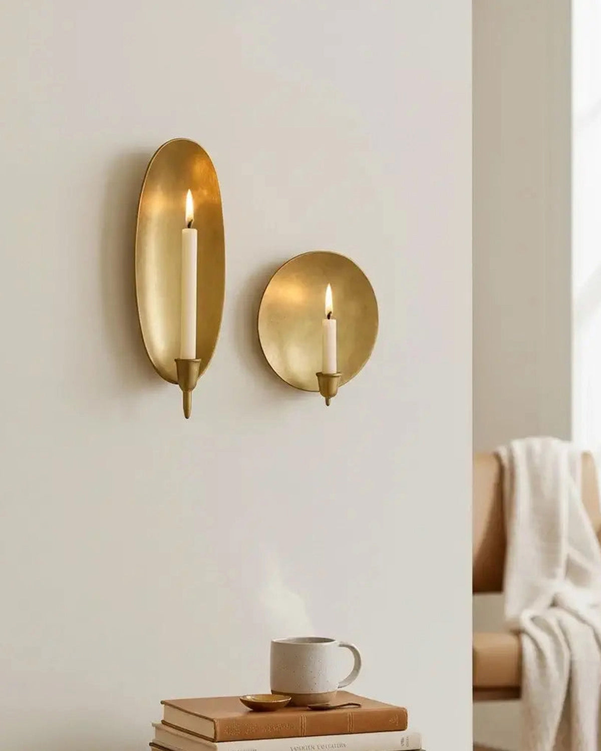Brass wall candle sconces by Two Faire with lit candles create a cozy ambiance above a styled side table.