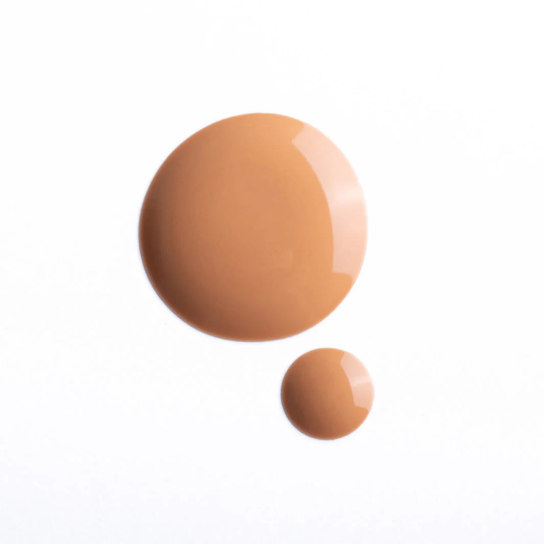 Two drops of Faire’s Moisturizing Tinted Serum in different sizes rest on a white background. The larger drop is at the top left, with the smaller below and to the right, highlighting its smooth, blendable formula.