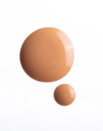 Two drops of Faire’s Moisturizing Tinted Serum in different sizes rest on a white background. The larger drop is at the top left, with the smaller below and to the right, highlighting its smooth, blendable formula.