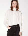 Roseanna Chemises loose-fit white shirt with stand-up collar and black studded skirt by Bungalow.
