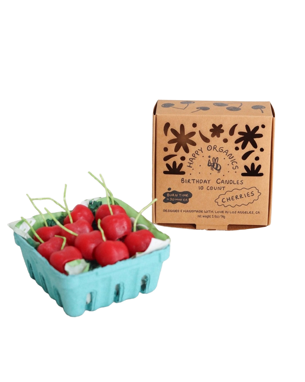 A blue carton containing cherry-shaped candles sits beside a brown box labeled “Faire Cherry Beeswax Candles,” decorated with simple plant doodles and handwritten-style text.