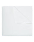 The John Robshaw Hand Stitched Coverlet Queen, in white organic cotton, is neatly folded to show its reversible design and subtle hand-stitched pattern for extra charm.