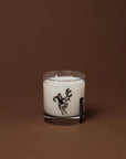 Double-wick soy wax Cowboy Christmas Candle featuring a black graphic of a cowboy riding a reindeer.