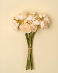 Cream ranunculus bouquet with green stems tied with twine by Faire.