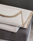Pattinson Blanket Stitch Coverlet by Eastern Accents displayed on a gray striped upholstered bench.