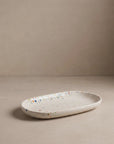 Oval Mini Tray by Bungalow Furniture & Accessories in white stoneware with a multi-colored speckled pattern.