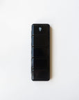 The Faire Watercolor Paint Palette is a black, rectangular palette with five compartments stacked vertically on a white background, resembling a compact pill organizer. The top compartment displays a white water bottle icon.