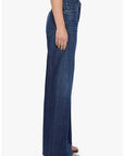 Mother Lil Lemon Twist Sneak high-waisted wide-leg jeans with twisted seams and navy blue heeled sandals, side view.
