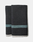 The CH Tea Towels S/2 by Faire feature dark gray linen with a horizontal teal stripe and thin light gray edge, shown folded side by side on a white background.