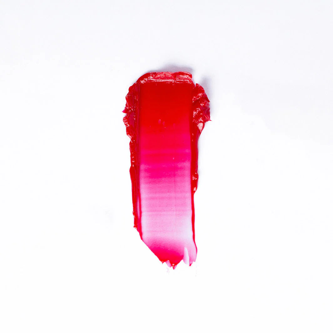 A swipe of Faire 03 Tinted Lip Balm & Blush on a white background shows a gradient from deep red to bright pink with a visible tinted, balm-like texture.