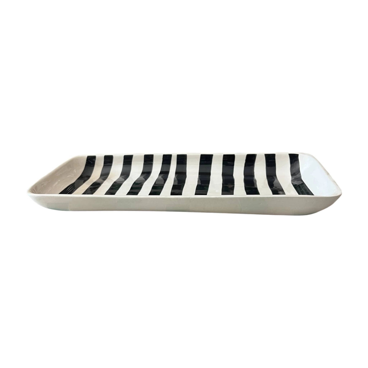 Black and white striped serving platter by Faire, shown side view with bold vertical stripes on a white background.