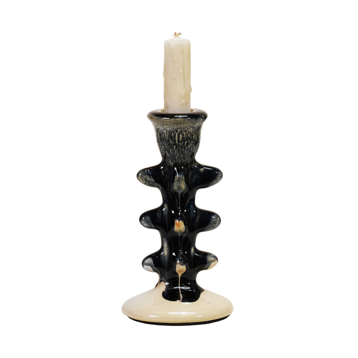 The Creative Co-op Terra-Cotta Taper Holder features a black and cream abstract wavy design, glossy finish, and holds a white candle. This sculptural piece adds modern flair to any room.