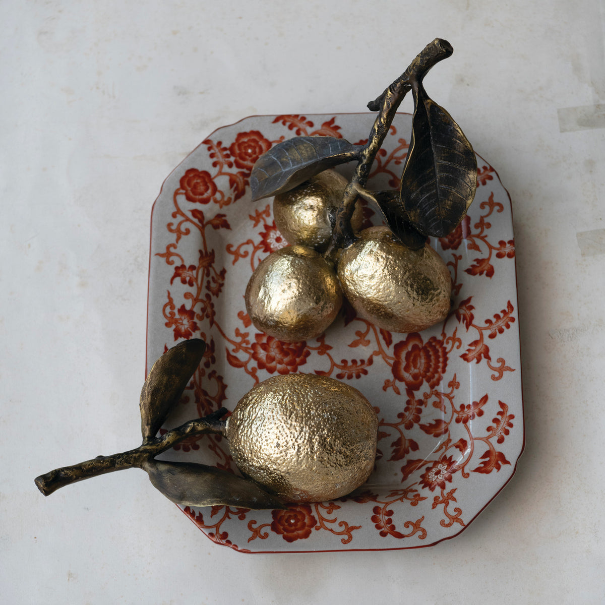 Ceramic lemon figurines with leaves on a floral plate by Creative Co-op, perfect decorative accent for any room.