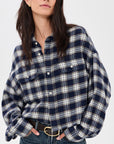 Cropped denim work shirt and jeans by Denimist, styled for a modern casual look, hands in pockets.