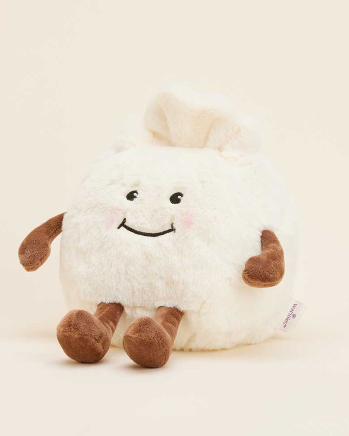 The Faire Dumpling Warmies is a microwavable plush toy shaped like a smiling dumpling with brown arms and legs, blushing cheeks, and a soft white body, shown sitting upright against a plain, light background.