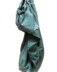 The Matte/Satin Biggy Pant by Free City (sparrow, LLC), featuring an oversized fit with elastic waistband and cuffs, hangs against a white background. The green drawcord pants showcase a relaxed, loose silhouette.