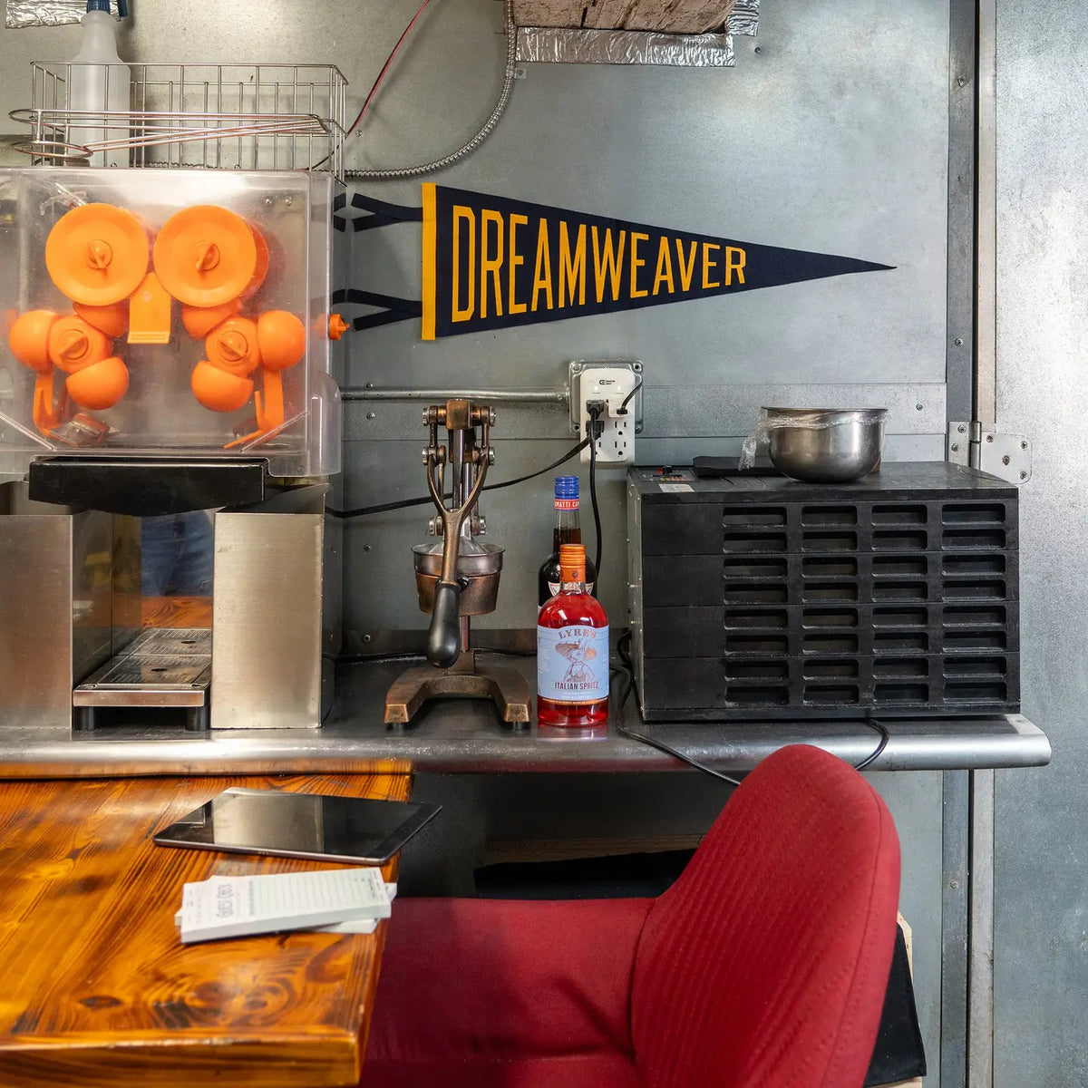 Dreamweaver Pennant by Faire displayed with an orange juice machine on a wood table in a modern kitchen setting.