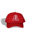 The El Surf Hat by Ping Pong Surf Club is a red foam trucker with a mesh back, snapback closure, and features a white stylized snake above “EL SURF” on the front. It’s displayed casting a left shadow on a white background.