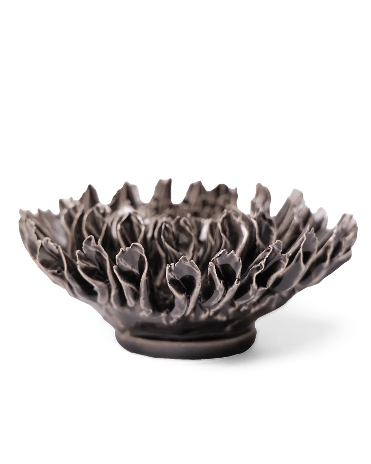 The Fractal Black Flower by Faire is a handmade pottery bowl with an intricate, floral-inspired design and wavy petal edges, displayed against a white background.