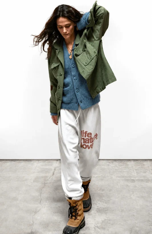 SuperYumm Norwegian Wool Pocket Cardi in blue layered under an olive utility jacket with white logo sweatpants.