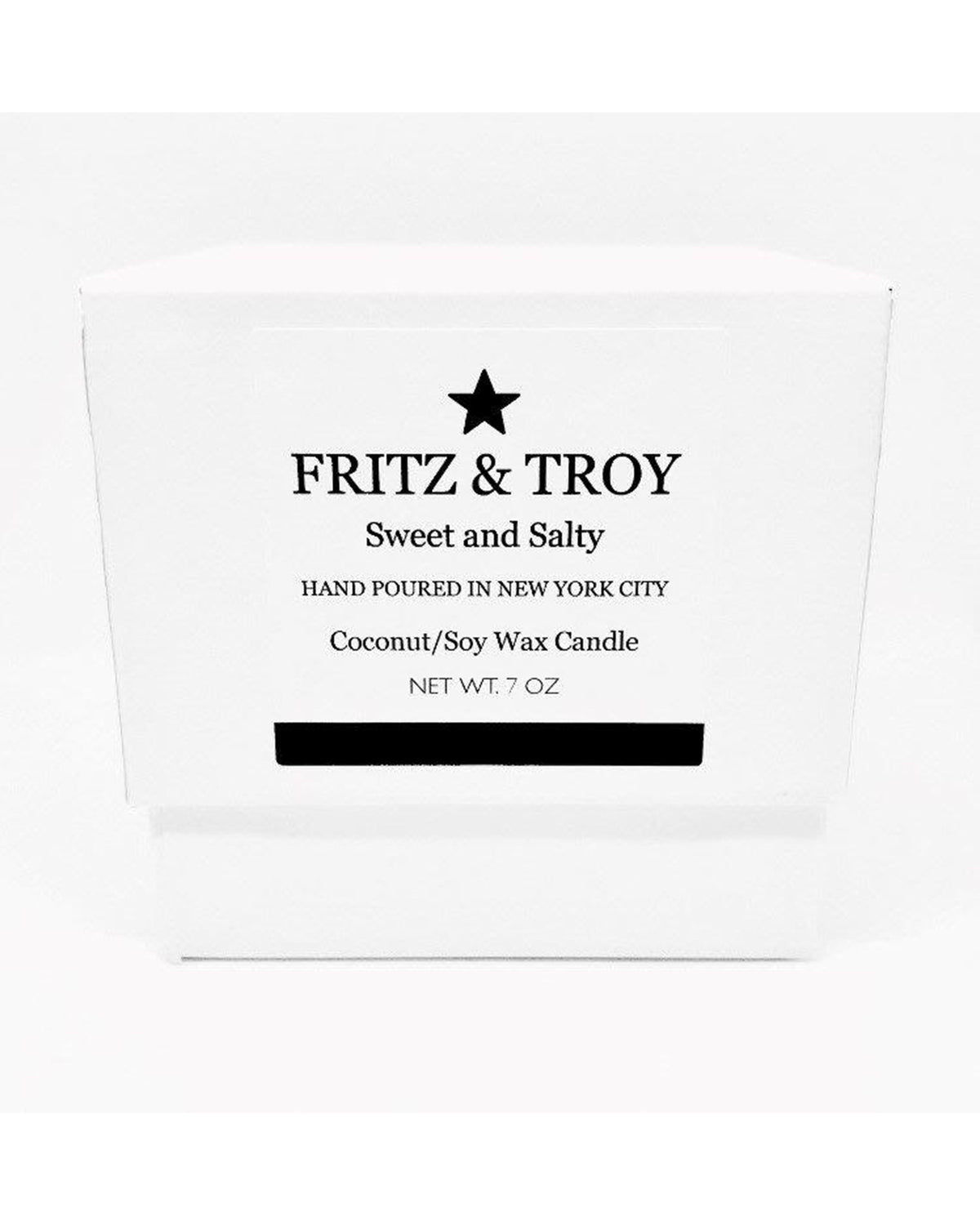 A white box with black text reads: "Fritz & Troy Sweet & Salty Candle. Hand poured in NYC. Coconut/soy wax candle with an oceanic accord. Net Wt. 7 oz." A black star sits above the brand name.