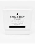 A white candle box labeled "Fritz & Troy Wild Child" holds a hand-poured coconut/soy wax candle made in NYC, with mandarin, jasmine, and amber notes. "NET WT. 7 OZ" is printed boldly on the front.