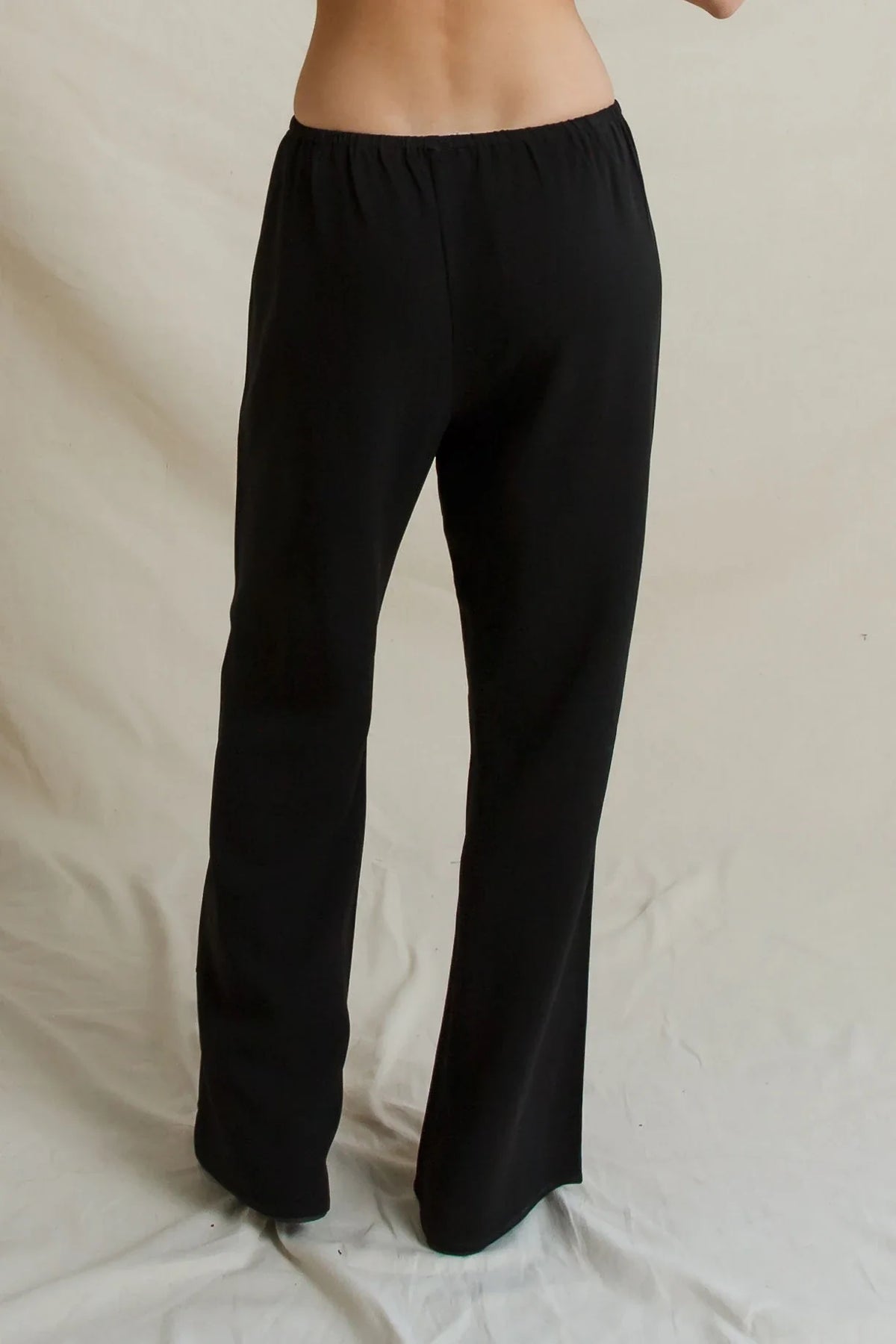 Black Georgia Crepe Pant with wide-leg, high-waisted fit and elastic waistband, back view.