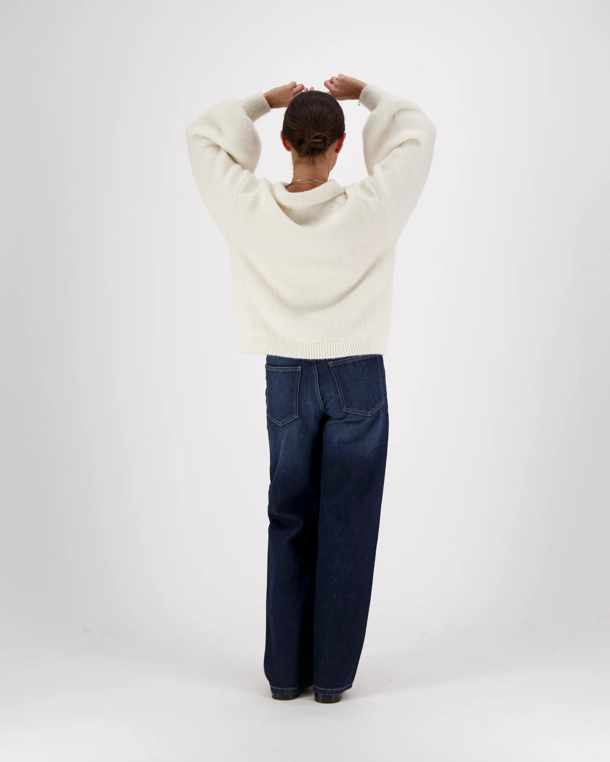 Mr Mittens Giselle Balloon Polo in oversized knit with balloon sleeves and wide-leg jeans, viewed from behind.