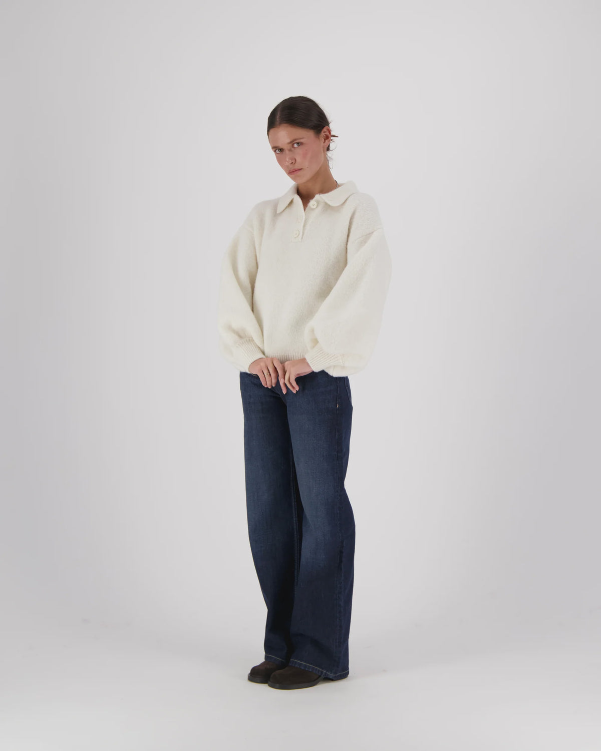 Oversized cream alpaca Giselle Balloon Polo sweater with voluminous sleeves, paired with dark blue wide-leg jeans.