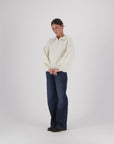 Oversized cream alpaca Giselle Balloon Polo sweater with voluminous sleeves, paired with dark blue wide-leg jeans.