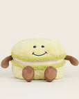 The Faire Green Macaroon Warmie is a light green plush toy shaped like a macaron with a smiling face, brown arms and legs. This microwavable plush offers sensory comfort for cozy relaxation.