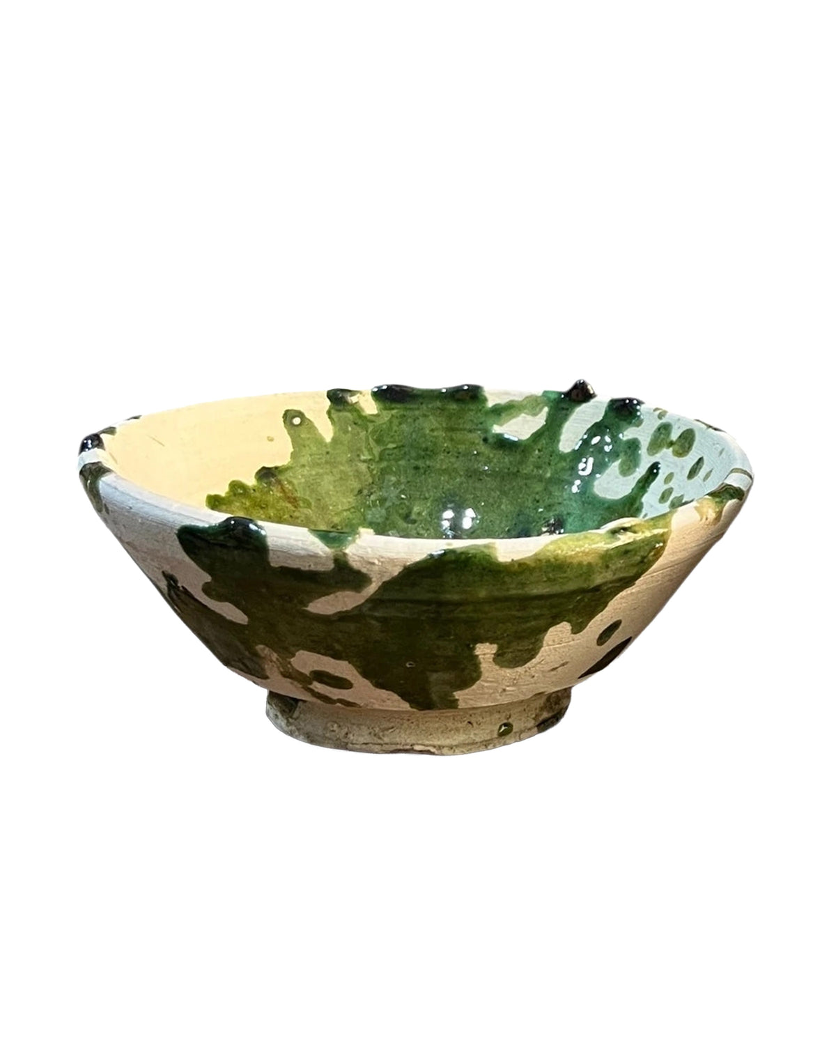 Shallow ceramic bowl with green splatter glaze on a cream base, Moroccan-inspired, by Faire.