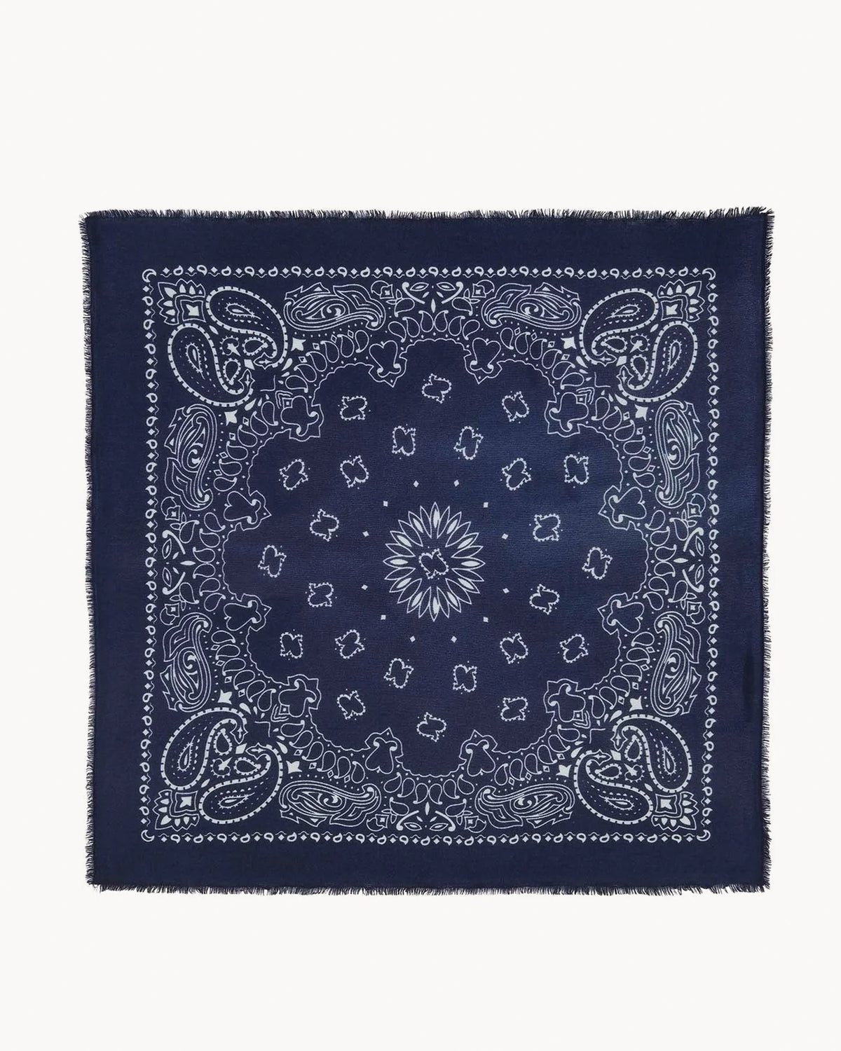 The Hachiko Scarf by KUJTEN is a navy blue square bandana made from soft printed cashmere with a white paisley and floral design, intricate borders, and fringed edges.