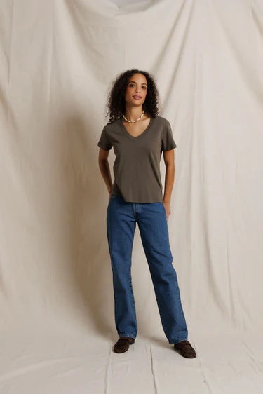 Gray boxy V-neck tee by Perfectwhitetee styled with blue jeans, shown in a neutral beige setting.