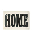 The Faire Home Block Decoupage Glass Tray features bold black vintage "HOME" lettering on a white background, adding handcrafted New York charm to any space.