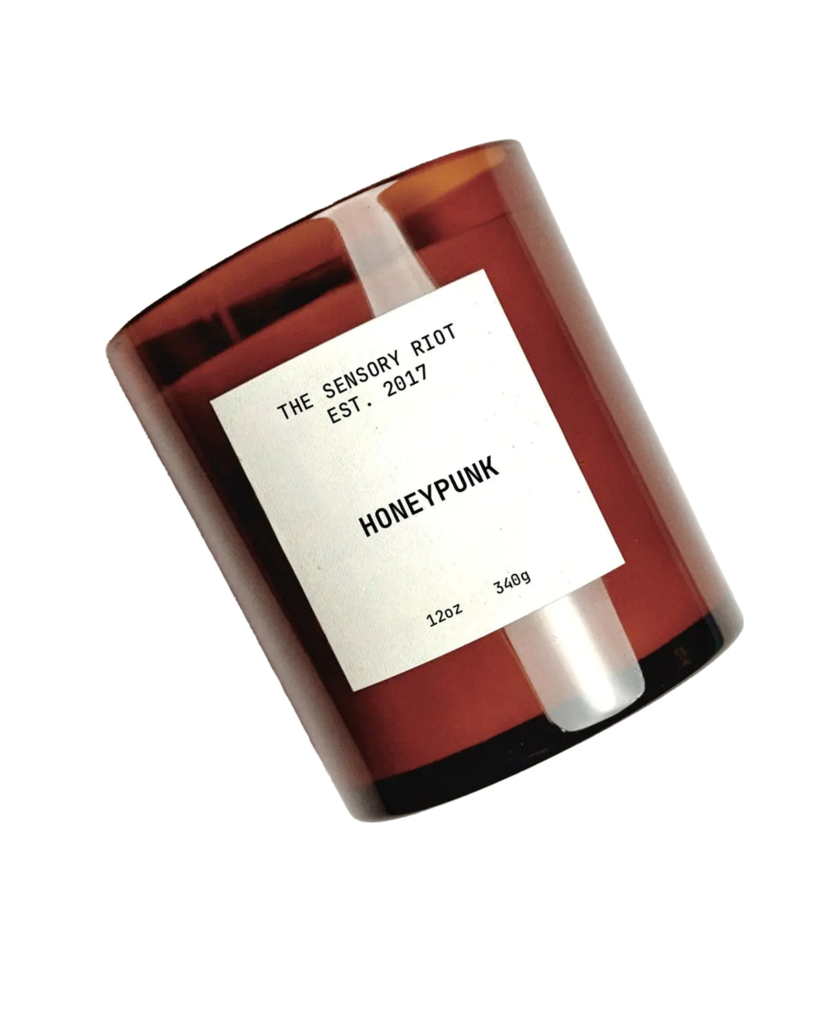 A brown glass HONEYPUNK 12 oz candle by Faire features a white label and sits against a white background. This non-toxic, vegan candle is crafted for mindful ambiance.