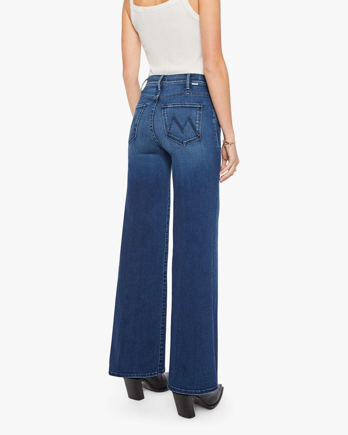Mother’s The Hustler Roller Sneak jeans in blue denim, styled with a white tank top, model shown from the back.