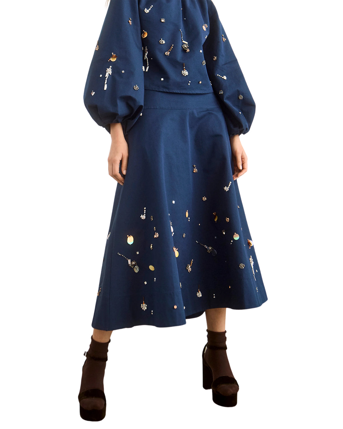 Ida Skirt by Hunter Bell NYC with embroidered blouse, styled with black heels and brown socks in a modern setting.