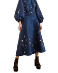 Ida Skirt by Hunter Bell NYC with embroidered blouse, styled with black heels and brown socks in a modern setting.