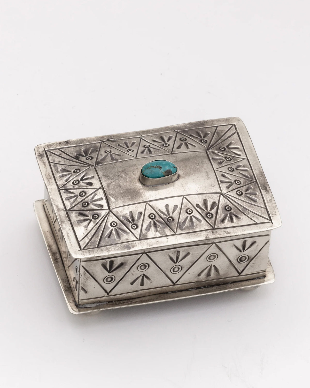 The J Alexander Rustic Silver 15-4-T Small Stamped Box w/ Turquoise features engraved geometric patterns and a turquoise stone centerpiece, adding Southwestern charm to any space. Shown on a plain white background.