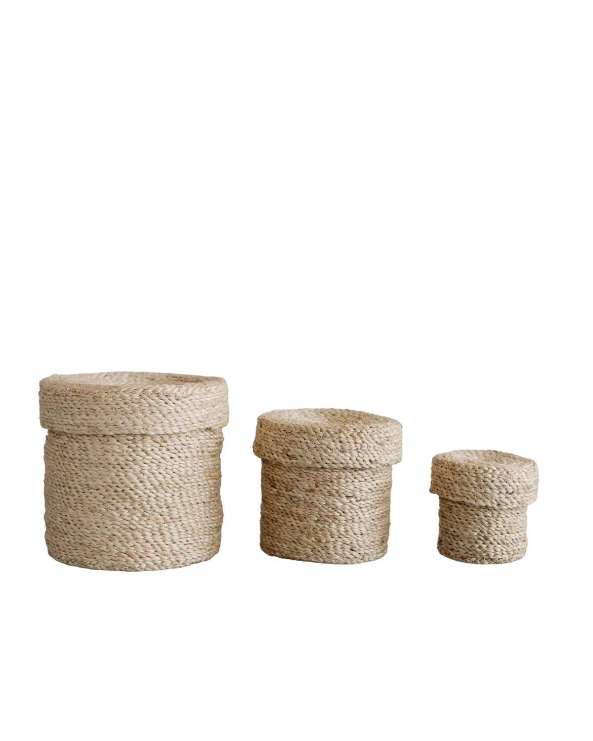 Three Faire Round Lidded Jute Baskets in natural color are arranged from largest to smallest on a white background.