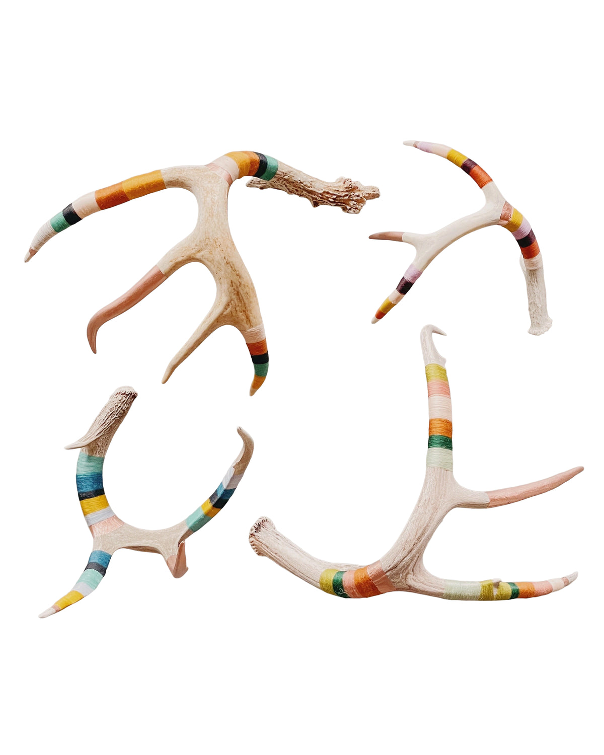 Four whitetail deer antlers wrapped in multicolored wool and copper wire, handcrafted by Bungalow Furniture &amp; Accessories.
