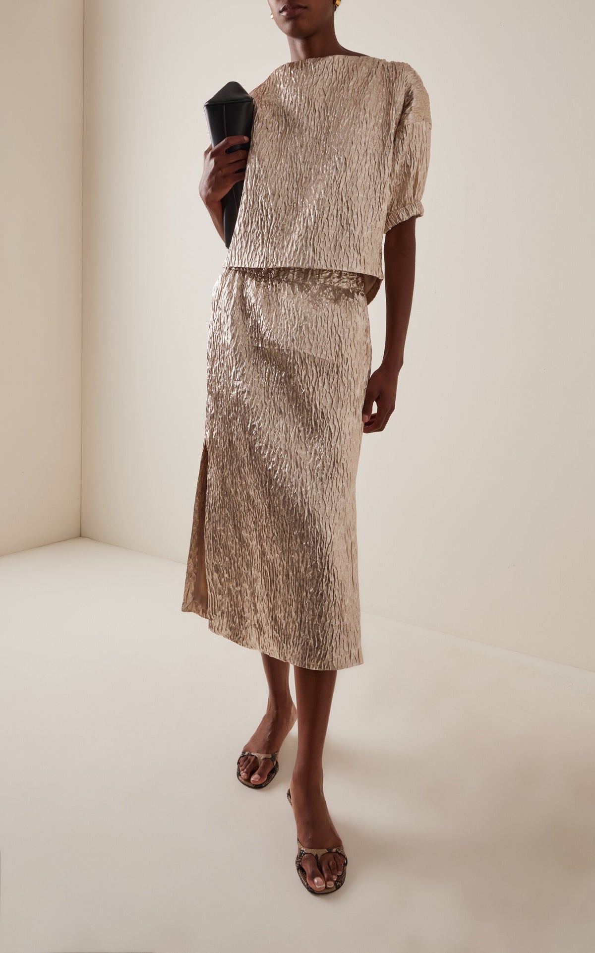 Rachel Comey Mott Skirt styled indoors with a black clutch and brown sandals, modern neutral interior setting.