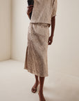Rachel Comey Mott Skirt styled indoors with a black clutch and brown sandals, modern neutral interior setting.