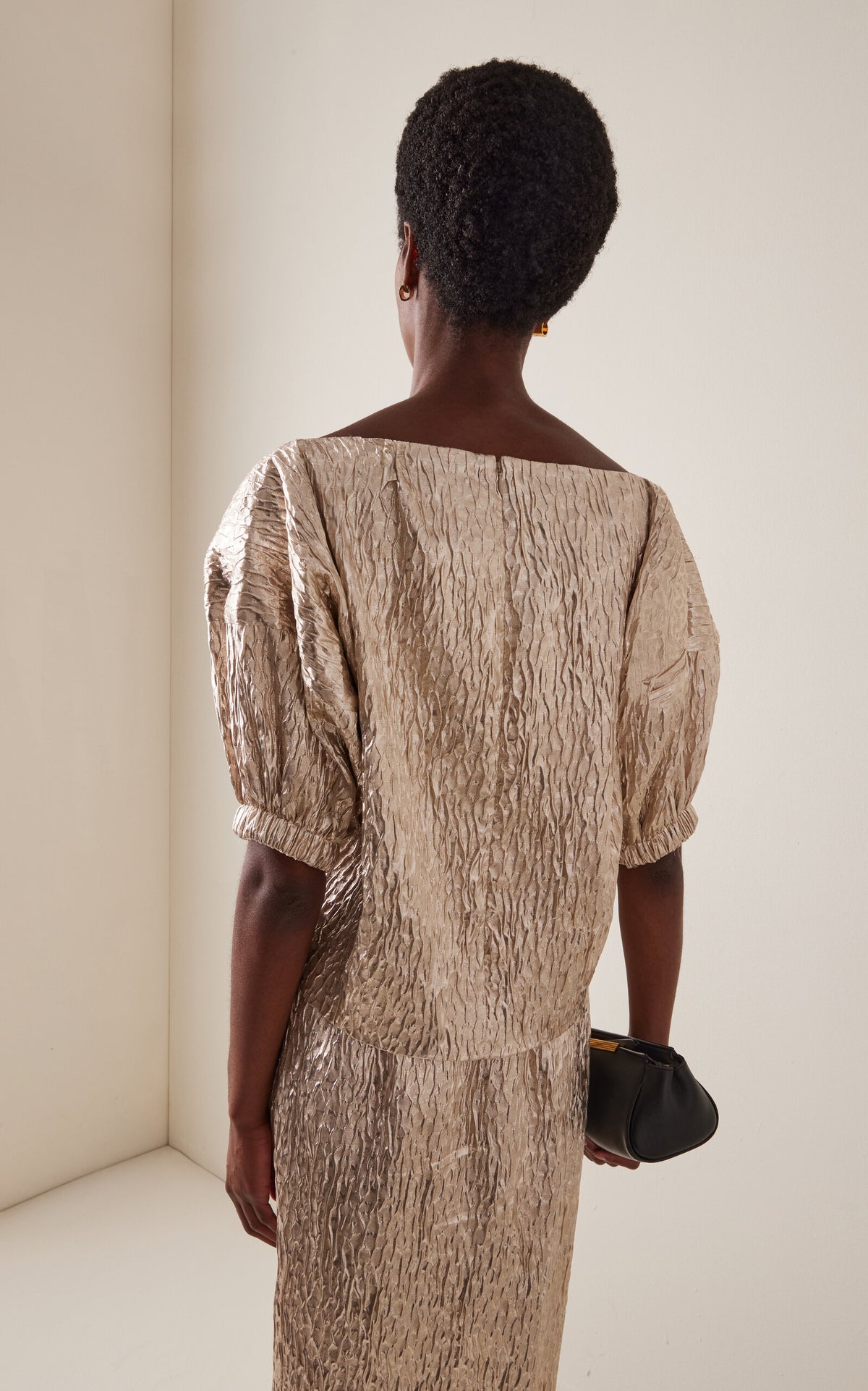 Textured gold Rachel Comey Filly Top with voluminous sleeves, styled with a small black clutch.