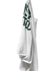White long sleeve tee with green text by Free City, Artistwanted Tubular style, displayed on a hook against white background.