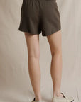 Brown Perfectwhitetee Layla Terry Shorts with elastic waist, styled with cream loafers against a simple backdrop.