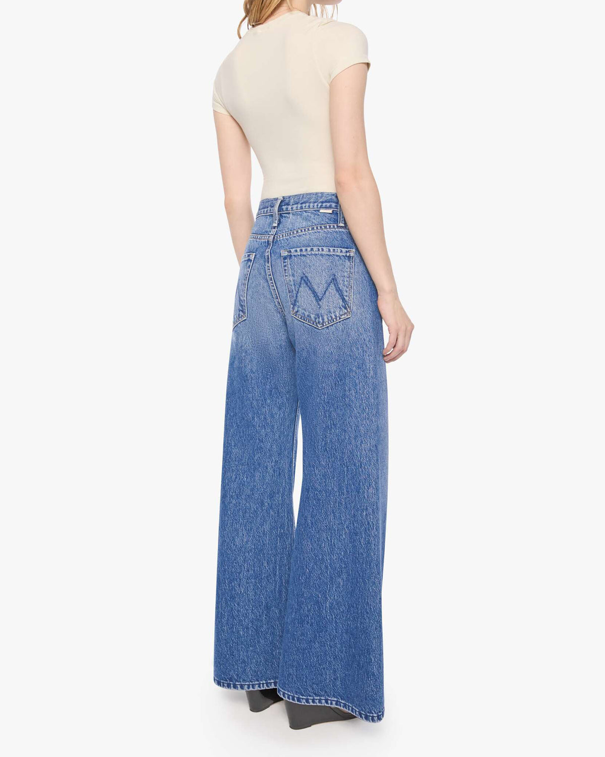 Mother’s Lil Lemon Twist Skimp petite wide leg jeans shown from the back, styled with a beige top.